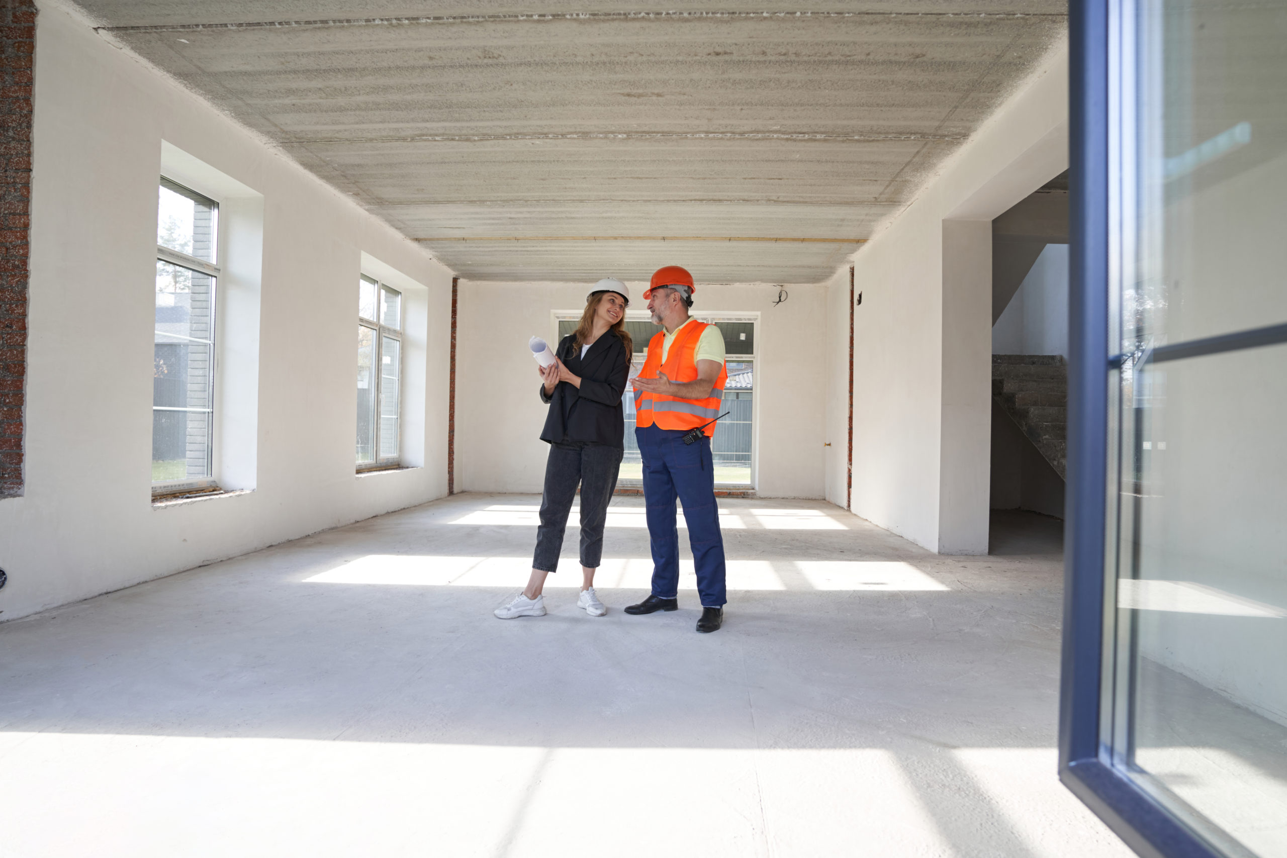a woman and a man speaking with each at a construction site